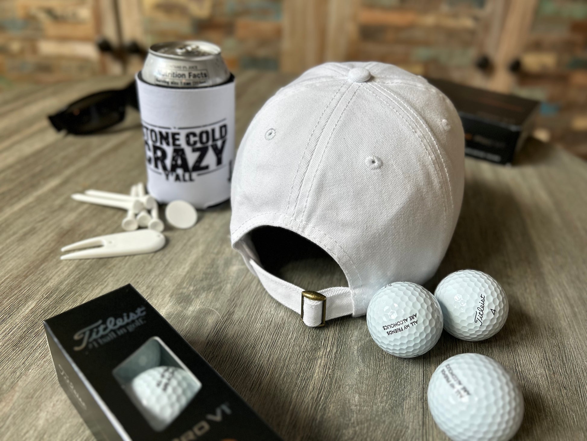 White cap, golf balls, and a can on a wooden surface with a blurred background
